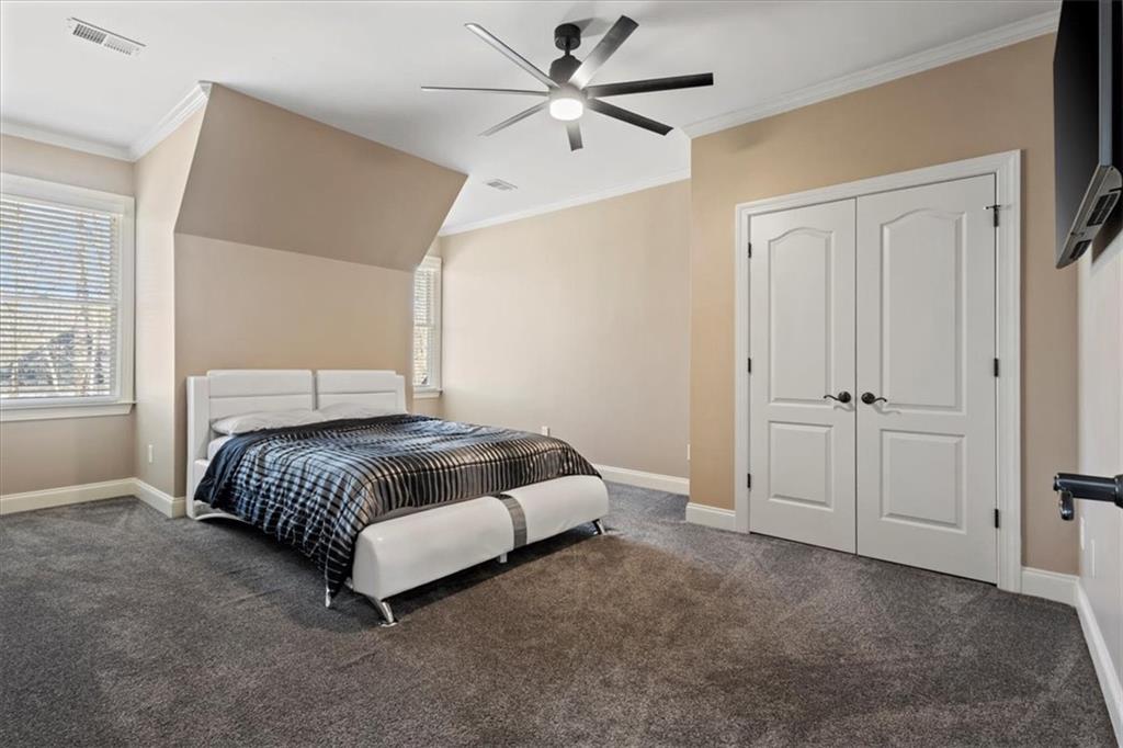 1859 Mountain Shadow Smoke Rise, GA 30087 - Photo 47 of 75 a spacious bedroom with a bed and a ceiling fan