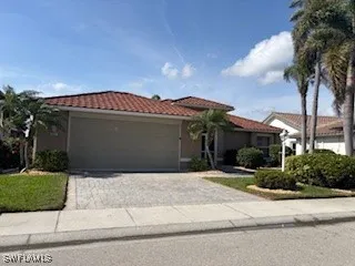 a front view of a house with a garden and a garage