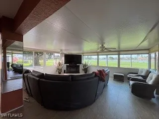 a living room with furniture tv and large windows