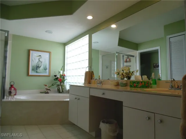 a bathroom with a sink mirror and a bathtub