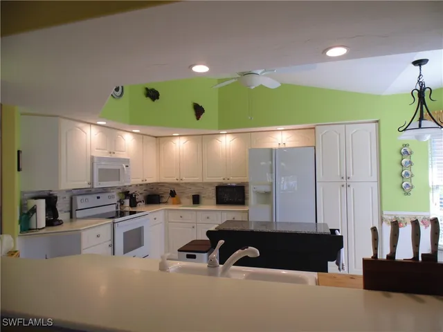 a kitchen with kitchen island granite countertop a sink and a stove