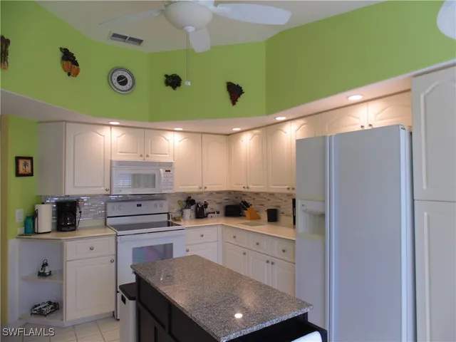 a kitchen with stainless steel appliances white cabinets and a refrigerator