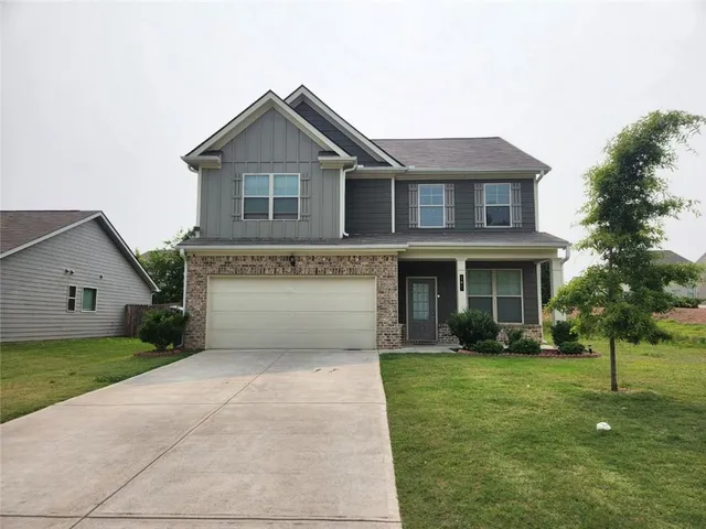 a front view of a house with a yard and trees