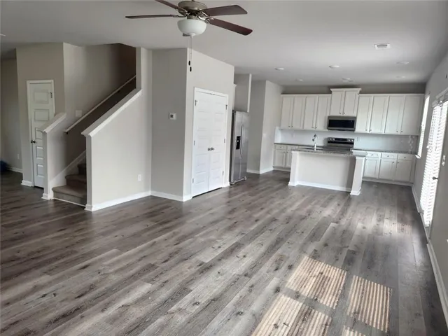 a view of kitchen with stainless steel appliances refrigerator stove microwave and cabinets