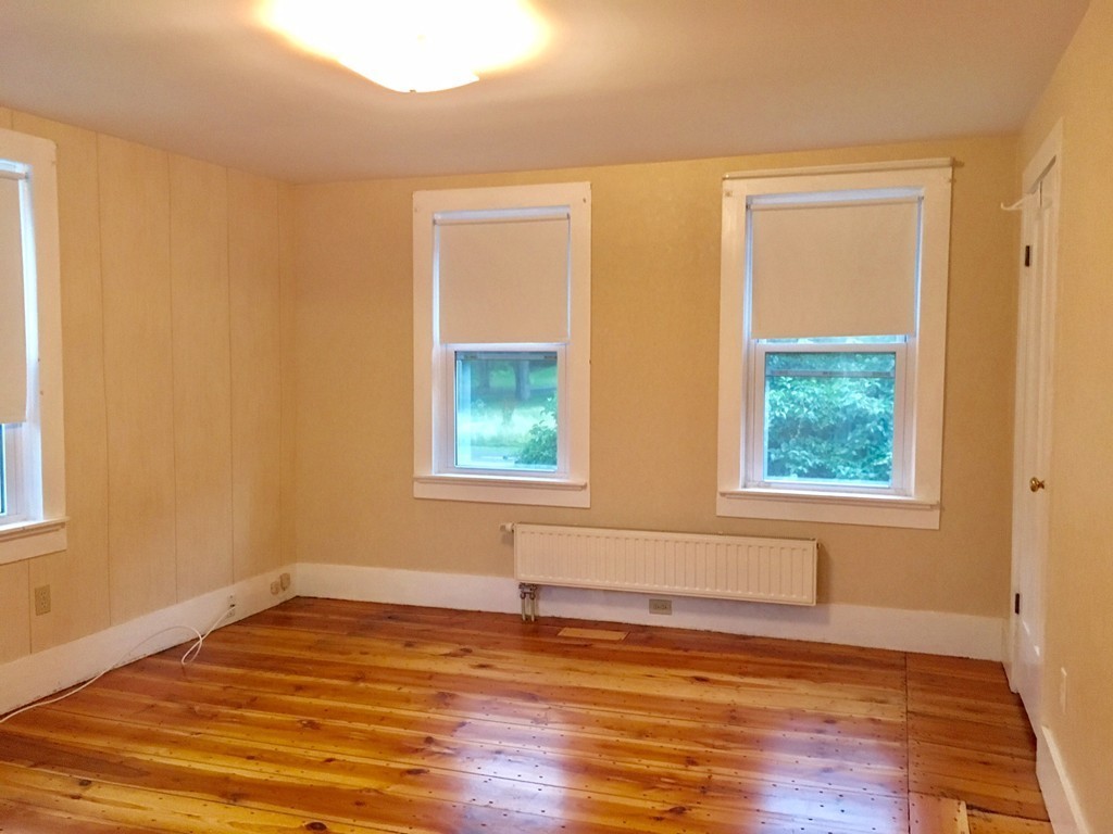 918 Chase Road Lunenburg, MA 01462 - Photo 8 of 30 a view of an empty room with wooden floor and a window