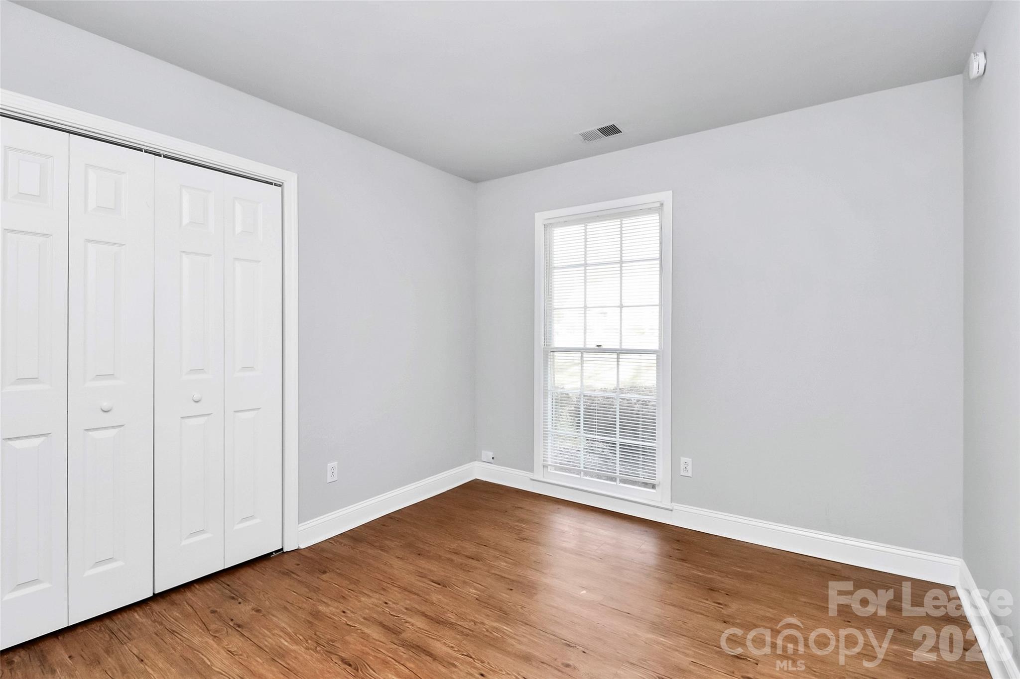 919 Pineborough Road Charlotte, NC 28212 - Photo 11 of 19 an empty room with wooden floor and windows