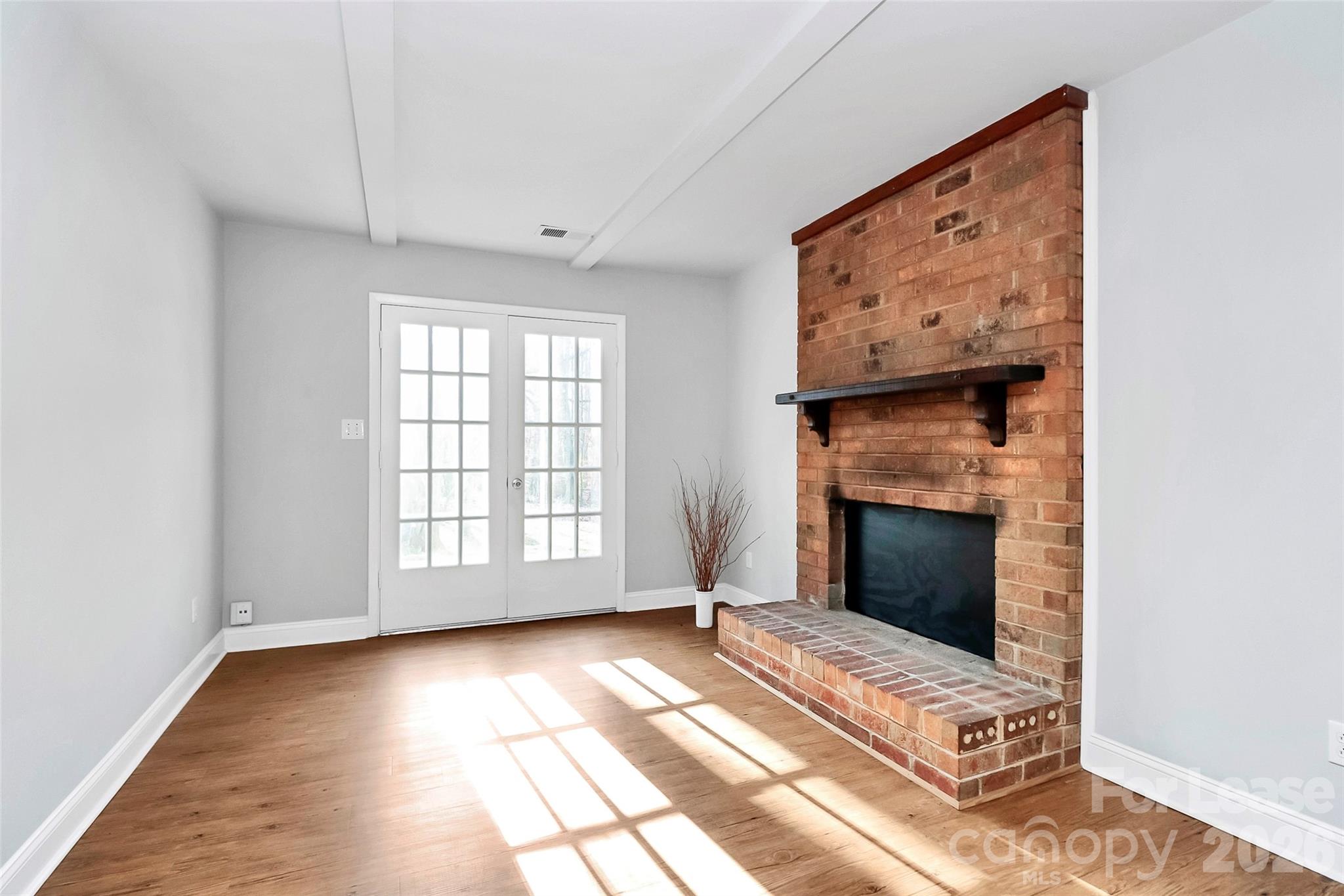 919 Pineborough Road Charlotte, NC 28212 - Photo 2 of 19 a view of an empty room with a fireplace and a window