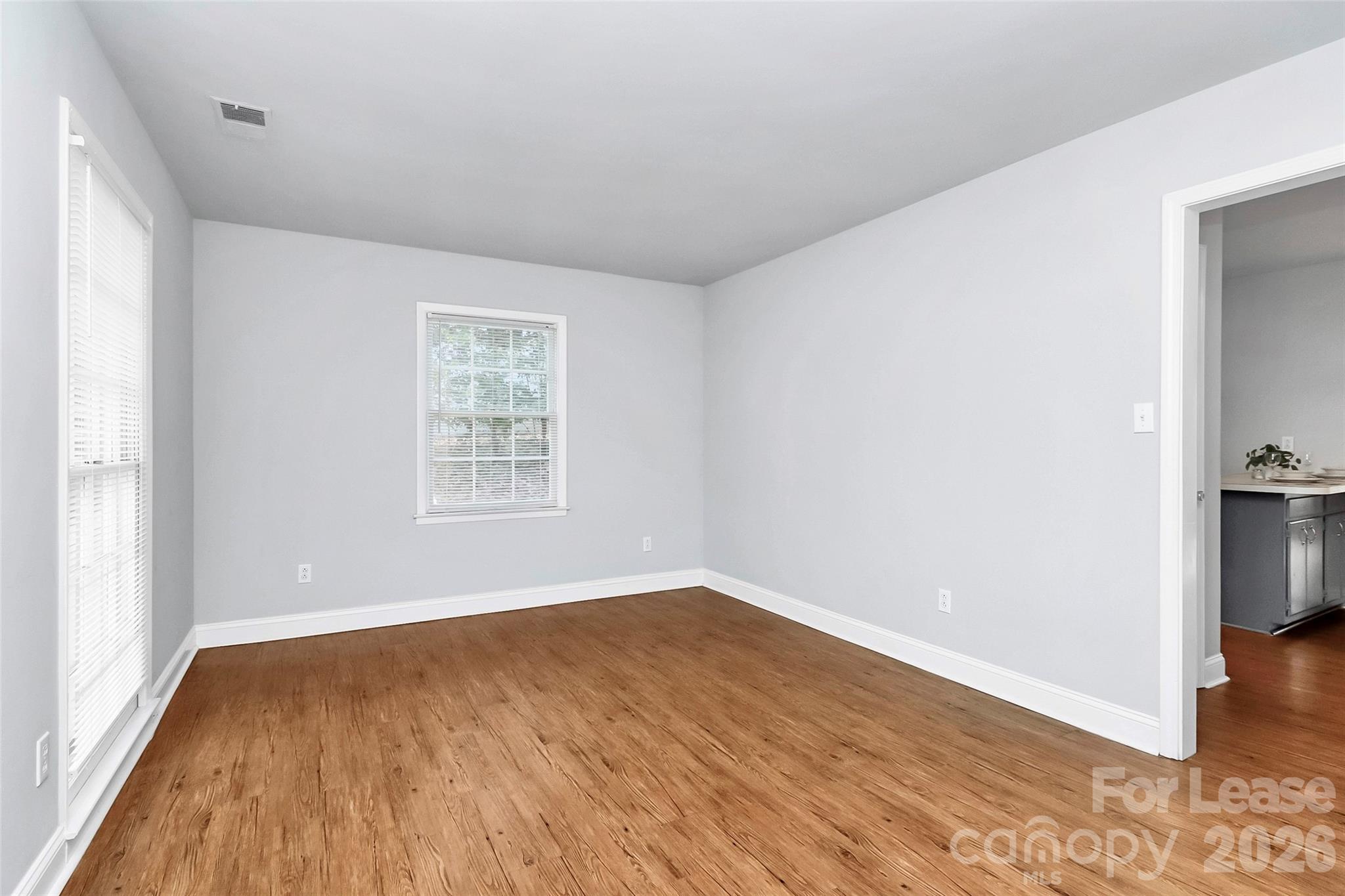 919 Pineborough Road Charlotte, NC 28212 - Photo 4 of 19 an empty room with wooden floor and windows