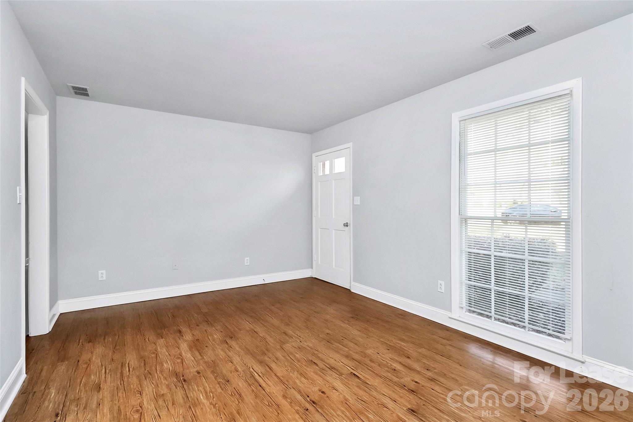 919 Pineborough Road Charlotte, NC 28212 - Photo 5 of 19 an empty room with wooden floor and windows