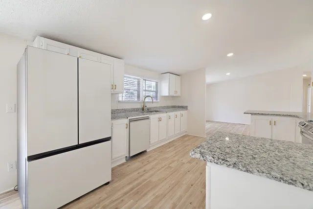 a view of kitchen with granite countertop cabinets and window