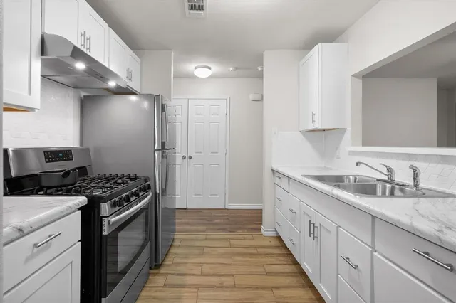 a kitchen with granite countertop a sink stove and cabinets