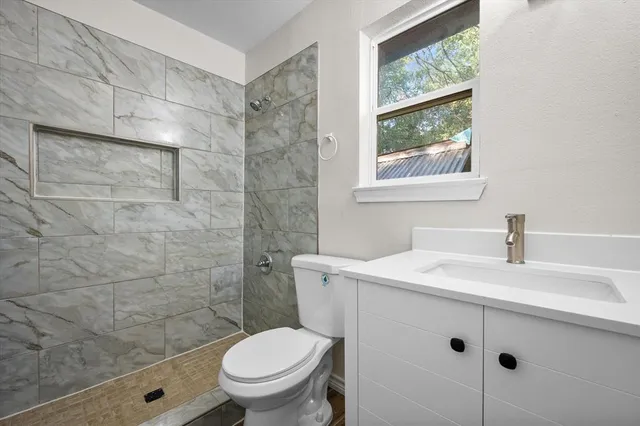 a bathroom with a sink a toilet and a window