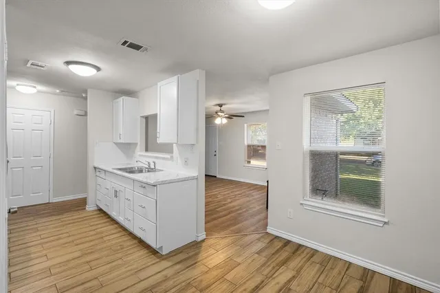 a kitchen with a sink and wooden floor