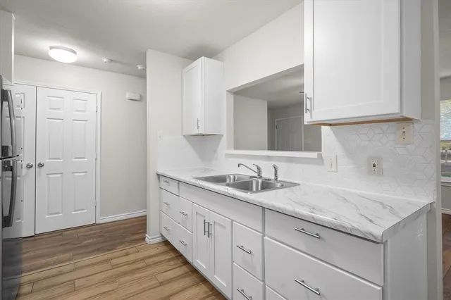 a spacious bathroom with a granite countertop sink and a mirror