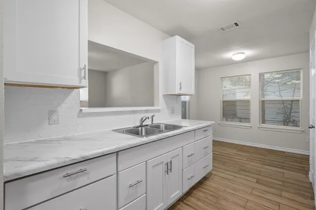 a bathroom with a granite countertop sink double vanity and a large mirror