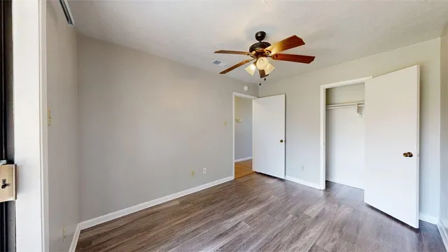 a view of a room with wooden floor and ceiling fan