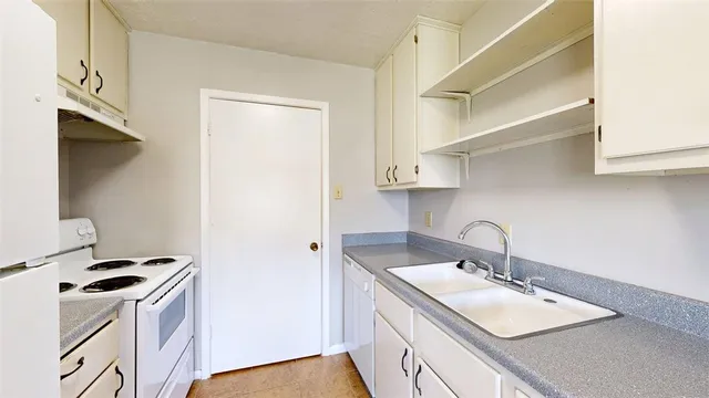 a kitchen with a sink a stove and a refrigerator