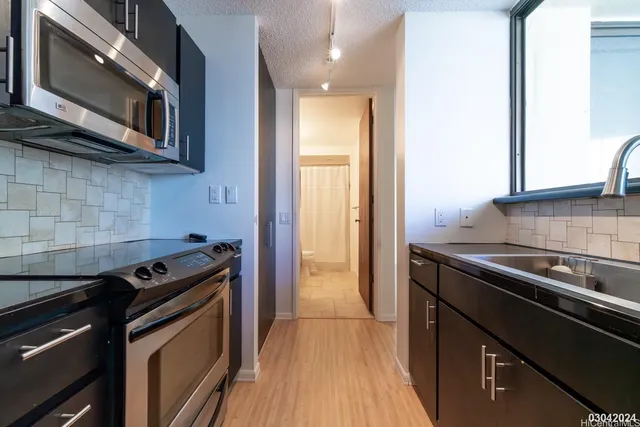 a kitchen with stainless steel appliances granite countertop a stove and a microwave
