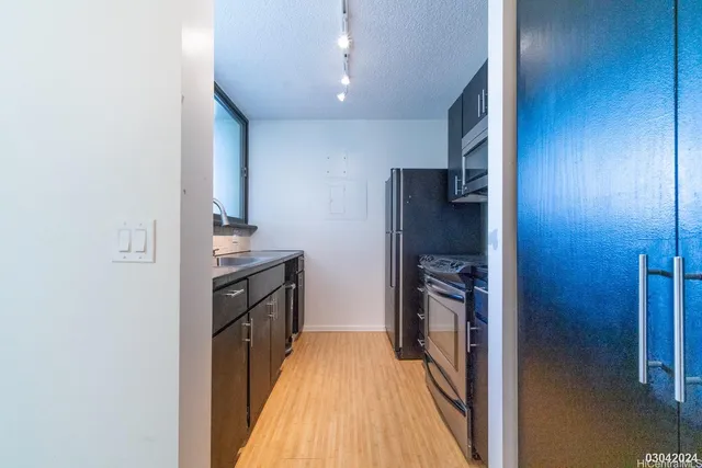 a kitchen with a refrigerator and a stove top oven