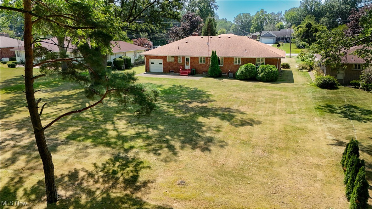 550 Cooper Foster Park Road Lorain, OH 44053 - Photo 47 of 50 View of green lawn with a residential view, a garage, and a patio area