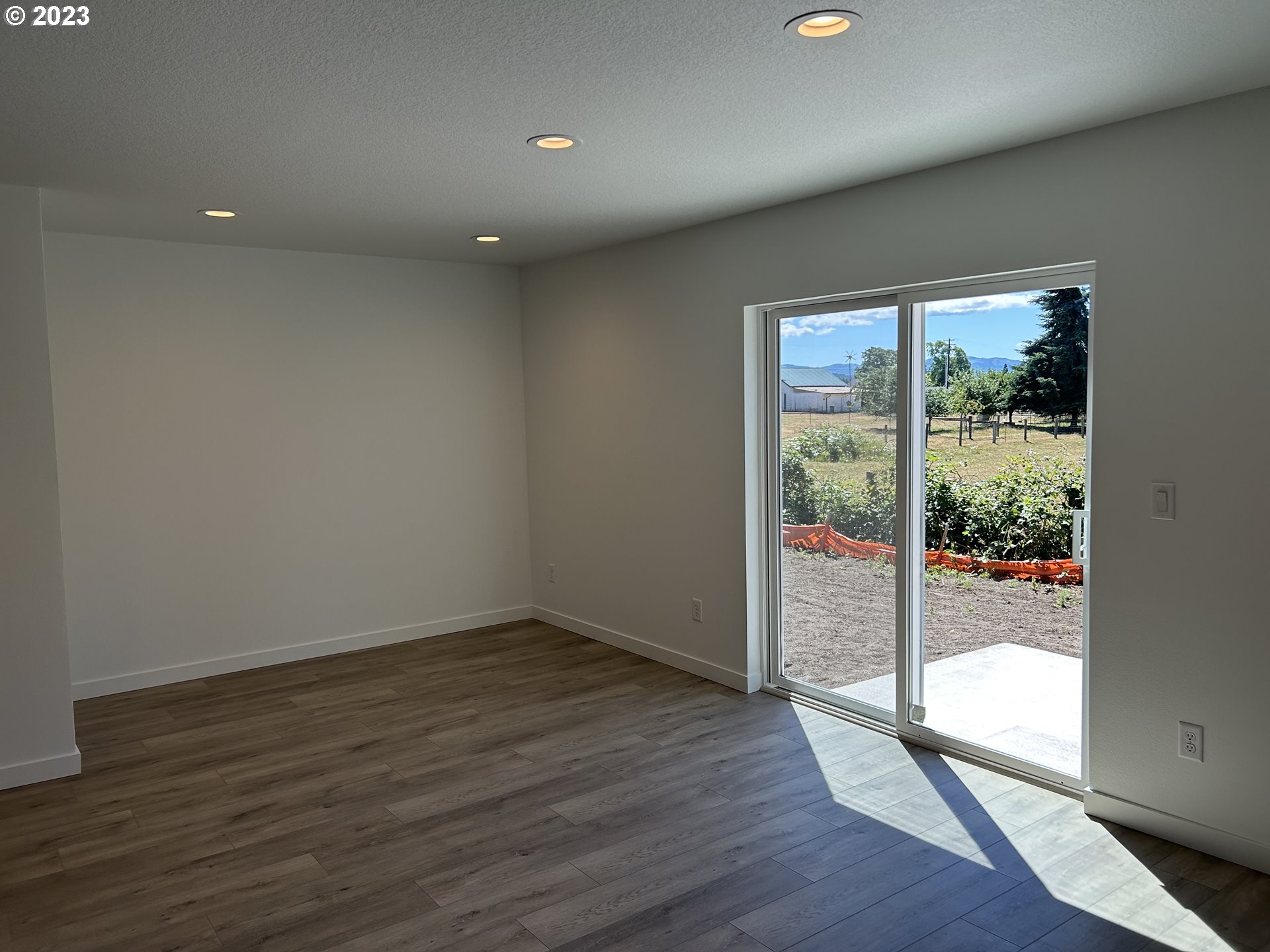 1006 Peach Road Winlock, WA 98596 - Photo 12 of 15 an empty room with wooden floor and windows
