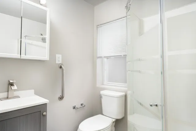 a white toilet sitting next to a bathroom sink