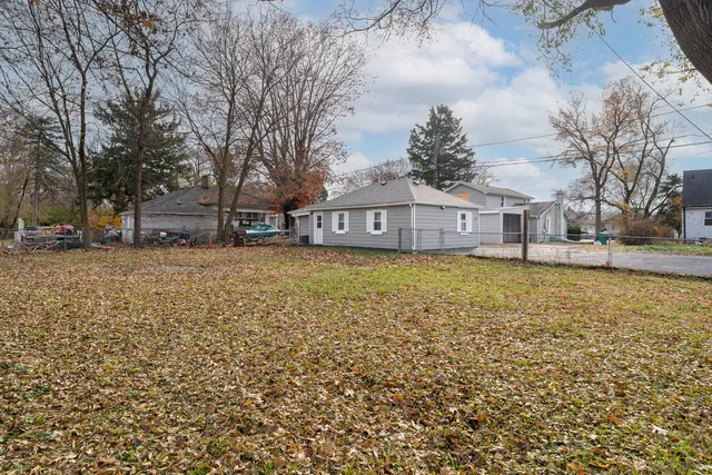 a view of a house with a big yard and large trees
