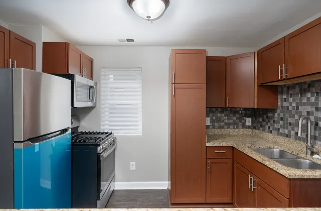 a kitchen with stainless steel appliances granite countertop a refrigerator and a sink