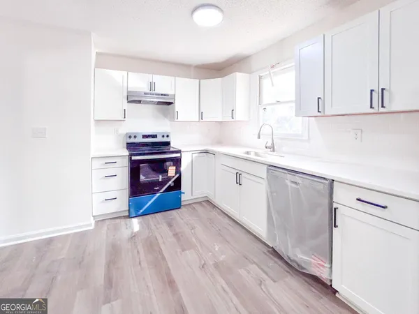 a kitchen with stainless steel appliances white cabinets and a sink
