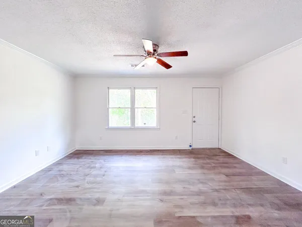 an empty room with windows and fan