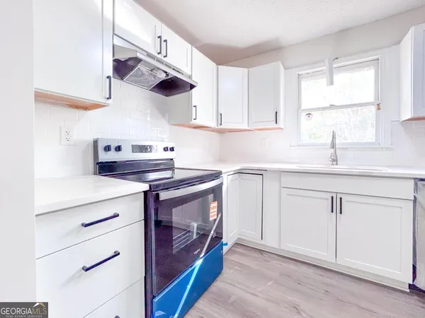 a kitchen with white cabinets stainless steel appliances and sink