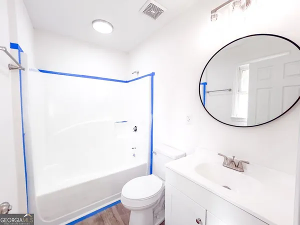 a bathroom with a sink a toilet and a mirror