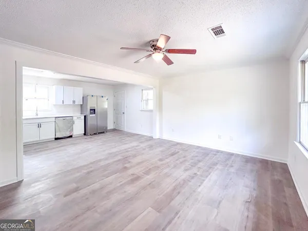 a view of empty room with wooden floor and window