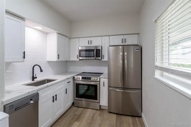 a kitchen with a refrigerator sink and stove top oven