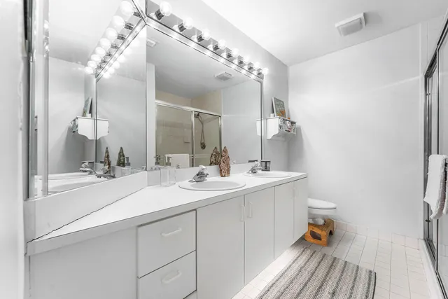 a bathroom with a sink and mirror with shower