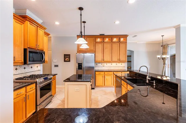 a kitchen with stainless steel appliances a stove sink refrigerator and microwave