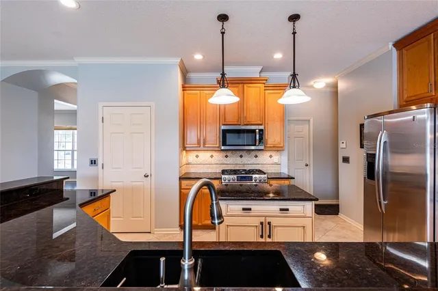 a kitchen with stainless steel appliances granite countertop a stove a sink and a refrigerator