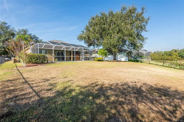 a view of a lake with a yard and large trees