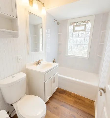 a bathroom with a sink mirror vanity and toilet