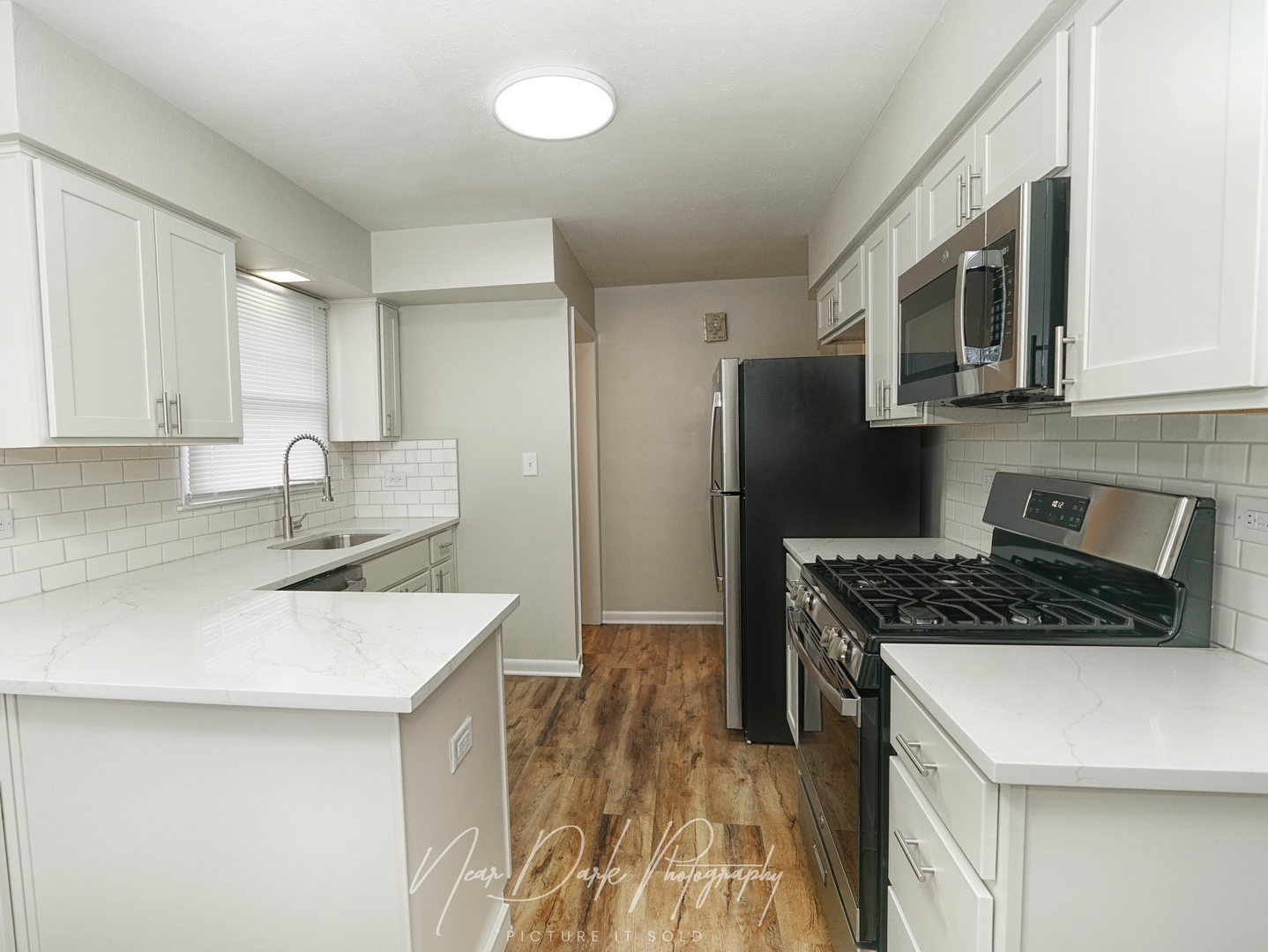 37684 North Sheridan Road Beach Park, IL 60087 - Photo 6 of 27 a kitchen with stainless steel appliances a sink a stove a microwave a refrigerator a cabinets and wooden floor