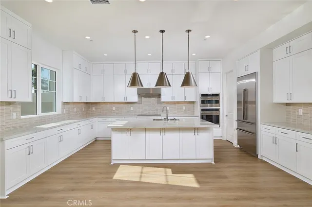 a large kitchen with stainless steel appliances kitchen island granite countertop a sink a stove a counter space and cabinets
