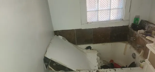 a bath tub sitting in a bathroom next to a window