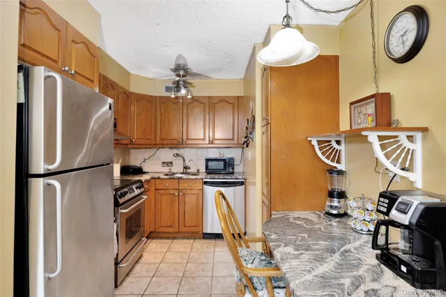 a kitchen with stainless steel appliances granite countertop a refrigerator a stove and a sink