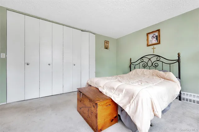 a bedroom with a bed and painting on the wall