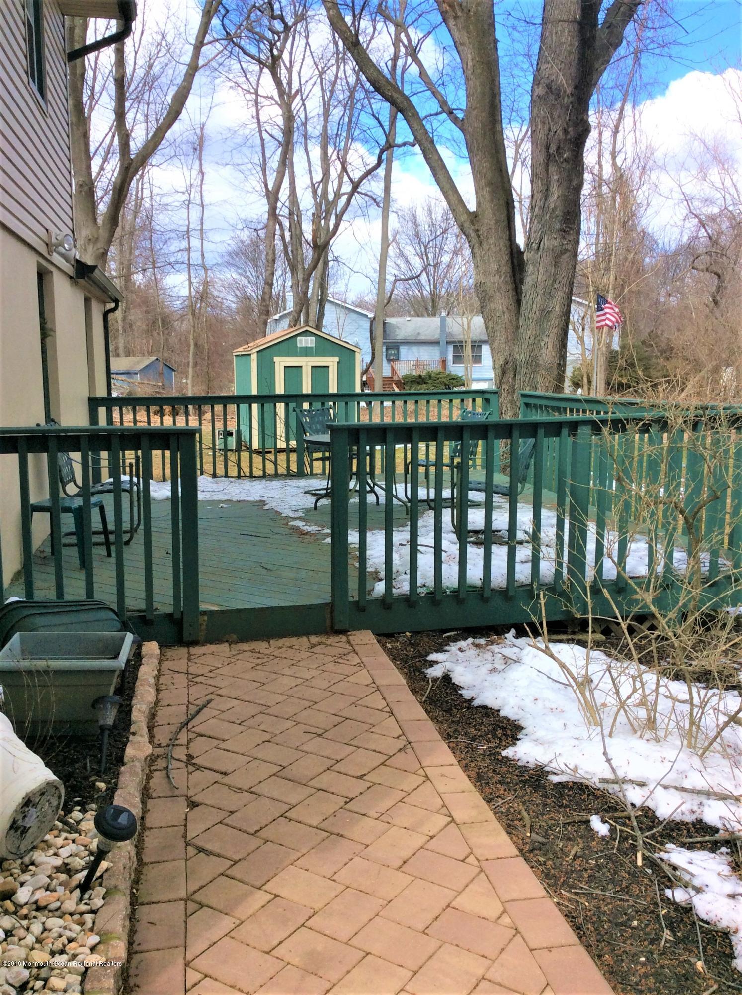 224 Old Mill Road Freehold, NJ 07728 - Photo 22 of 25 a view of a wooden deck next to a yard