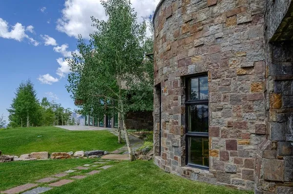 a view of a door in front of a brick house with a yard