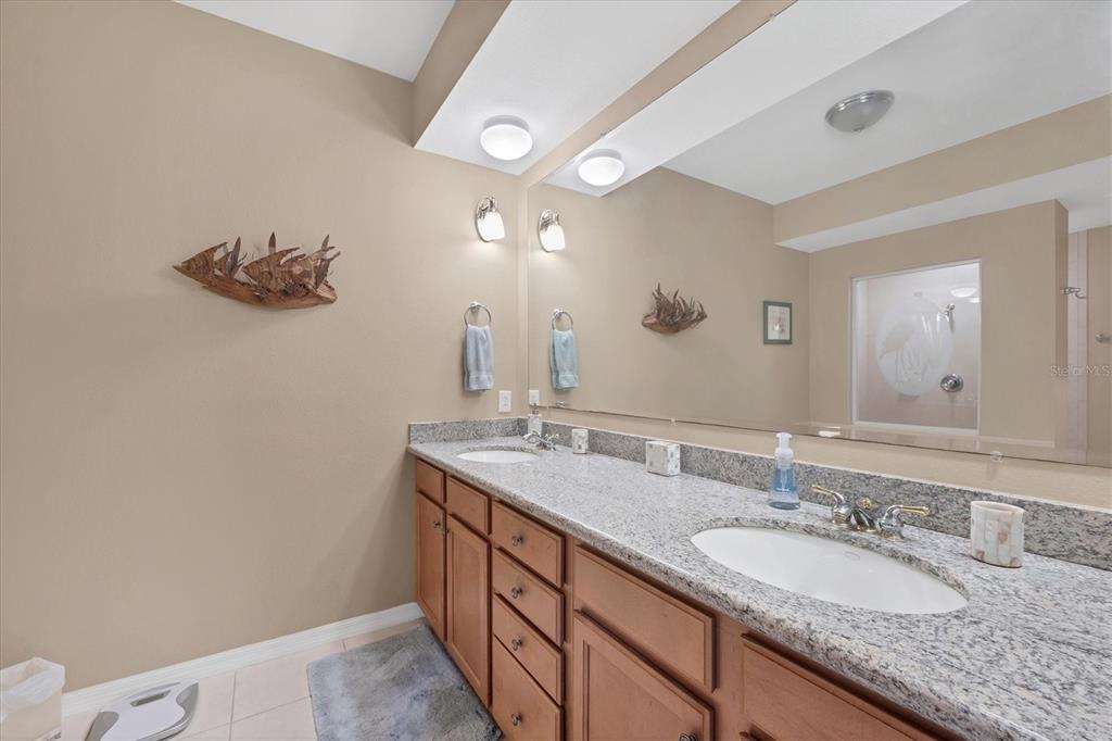 9203 Griggs Road, Unit A302 Englewood, FL 34224 - Photo 22 of 42 a bathroom with a granite countertop sink and a mirror