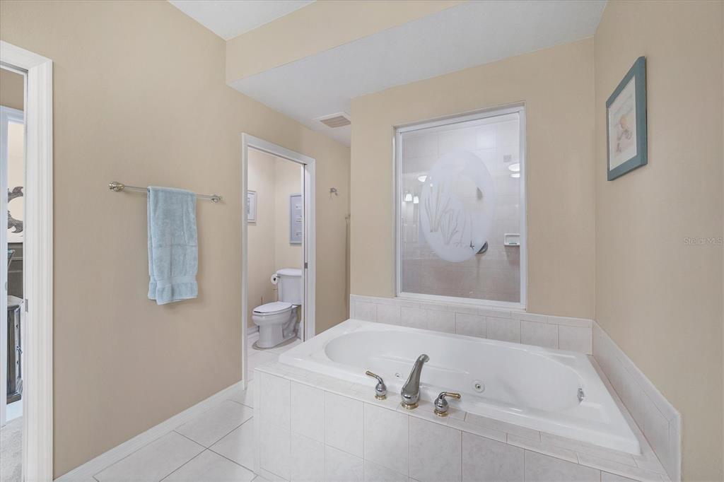 9203 Griggs Road, Unit A302 Englewood, FL 34224 - Photo 24 of 42 a bathroom with a tub and a shower