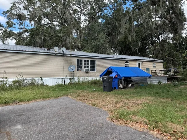 a view of a house with backyard and sitting area