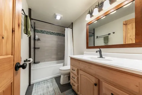a bathroom with a granite countertop sink toilet and shower